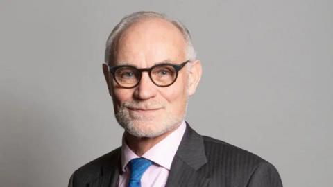 A close up head and shoulders image of Crispin Blunt