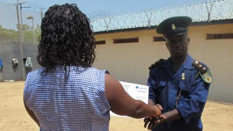 Guard hands certificate to an inmate