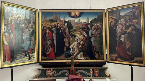 The triptych displayed above the almshouse altar. The side panels are turned inwards at 45 degrees. Each of the three panels is in a gold frame.