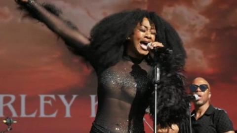 Beverley Knight performing at Godiva Festival 2024. Her right arm is outstretched and her left arm is holding a microphone.