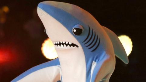Katy Perry singing at the Superbowl flanked by people dressed as sharks