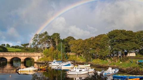 Rainbow over river boats