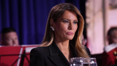 Melania Trump wearing a black blazer and diamond earrings at the White House Correspondents' Association dinner