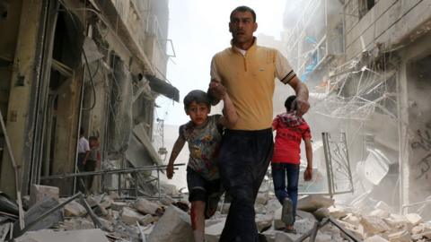 A Syrian man evacuates an area following a reported airstrike on April 22, 2016 in Aleppo