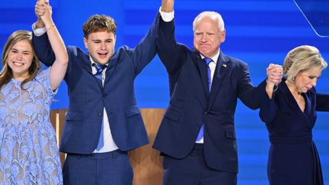 Hope, Gus, Tim and Gwen Walz lock hands while celebrating onstage at the Democratic National Congress in Chicago on 21 August