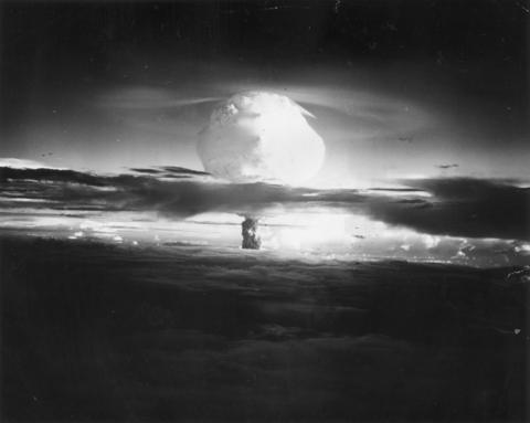 A black and white image of mushroom cloud caused by a huge explosion