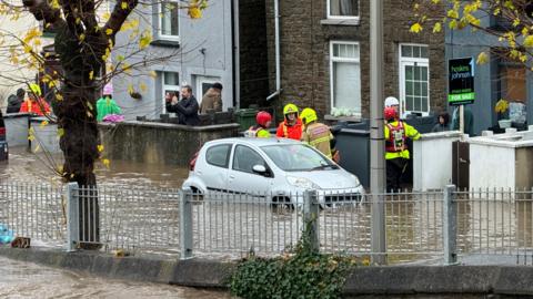 Emergency services wade through flood water