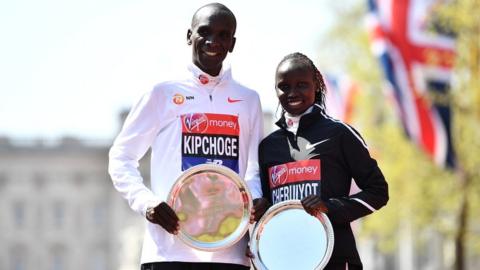Eliud Kipchoge and Vivian Cheruiyot of Kenya pose as they receive their trophies, following their first place results during the Virgin Money London Marathon on 22 April 2018