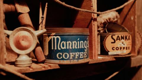 A blue tin from Manning's Coffee and a brown tin saying Sanka Coffee