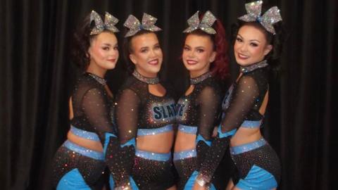 (L-R) Karen Breslin, Orla McConnell, Clodagh McGonagle and Megan Moore. They are all their cheer uniforms with big silver bows in their hair and blue and black costumes. 