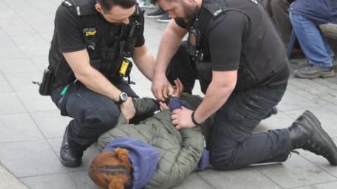 Police arresting a woman for carrying a knife