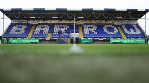 A shot of one of the stands at Barrow's Holker Street ground with 'BARROW' written across the seats