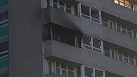 A close-up of the affected flat, showing smoke damage around a blackened window