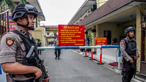 Armed police keep watch at a security checkpoint at a police headquarters in Medan city, North Sumatra province, on May 15, 2018,