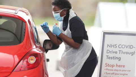 A nurse takes a swab at a Covid-19 Drive-Through testing station for NHS staff on March 30, 2020 in Chessington, United Kingdom
