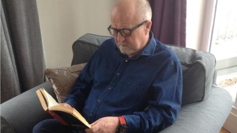 John Skinner reading a book