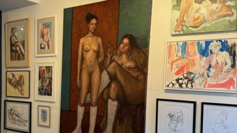 Gallery wall featuring both canvas and framed life drawings of men and women. 