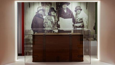 Mae'r arddangosfa yn cynnwys lluniau o'r gist bren a'r pedair a gyflwynodd y ddeiseb yn Washington yn 1924