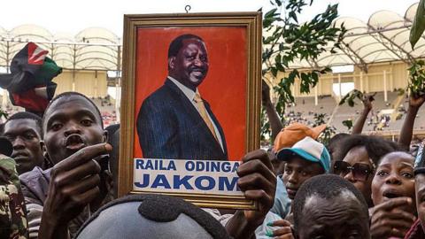 A mourner holds Raila Odinga's portrait