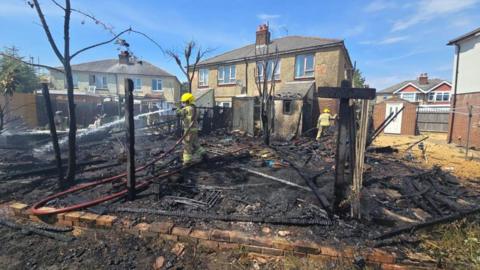 Gardens and fences left charred after a bonfire.