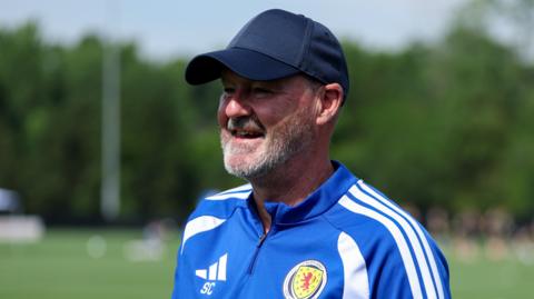 Scotland manager Steve Clarke smiles with a cap on