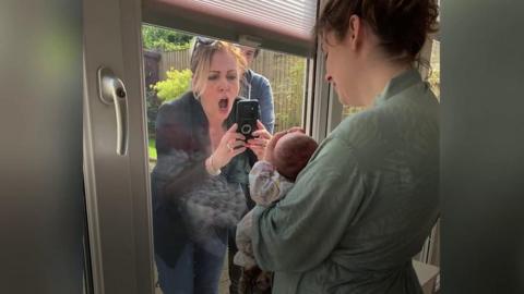 Grandmother Laura Dally met her first grandchild through her son's window