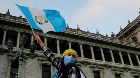 A woman holds up a Guatemalan flag, during a protest to demand the resignation of President Alejandro Giammattei on November 22, 2020.