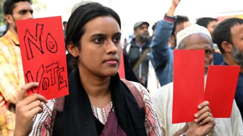Activists from the Leftist Party's Alliance 'Ganatantra Mancha' are holding red cards as they participate in a rally to protest against the upcoming 2024 general elections in Dhaka, Bangladesh, on December 30, 2023.