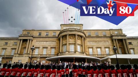 beefeaters stand on ceremony outside buckingham palace as red arrows fly over the palace