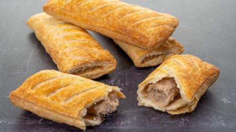 Stock image of sausage rolls laid out on a surface.