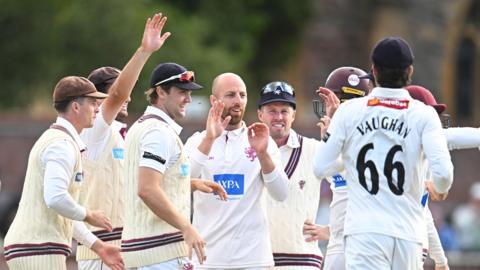 Jack Leach all smiles in the centre, surrounded by Somerset team-mates after taking a wicket
