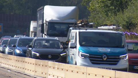 Traffic shown on M27 near Eastleigh in Hampshire. It's a sunny day.