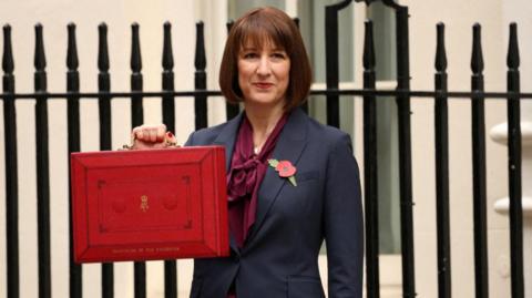 Rachel Reeves holding her red Treasury case outside 11 Downing Street on budget day