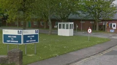 Entrance to HMP Kirkham prison building showing a sign which reads: "Welcome to HMP Kirkham". 