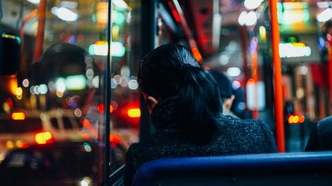 Woman sitting on a bus at night