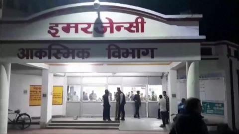 Police and concerned family members outside the affected hospital in Jhansi on 15/11