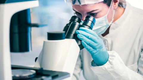 Woman looking into microscope