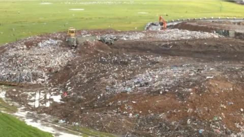 Landfill site with diggers moving waste