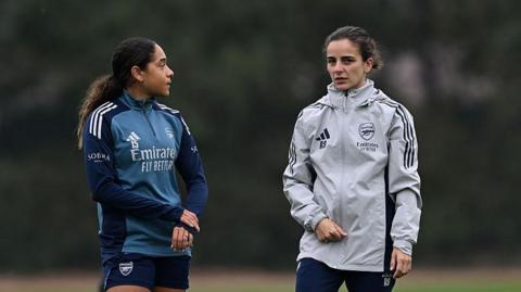 Smith and Slegers chat during training
