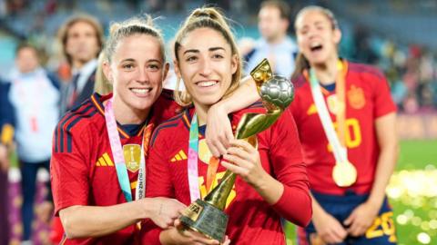 Olga Carmona and Ona Batlle hold the World Cup trophy