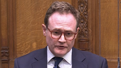 Tom Tugendhatwearing brown glasses and a navy suit in the House of Commons.
