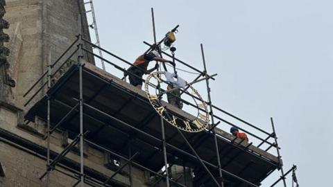 A clock being lifted into place