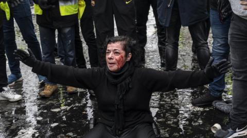 Teargas surrounds protesters as they clash with riot police during a "Yellow Vest" demonstration near the Arc de Triomphe on December 1,