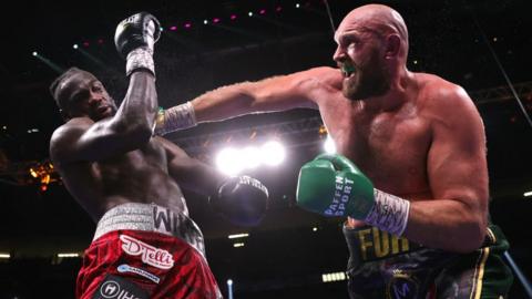 Tyson Fury punches Deontay Wilder