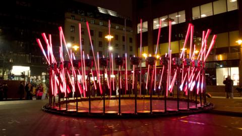 Red light poles on a circular metal frame outside a Birmingham railway station