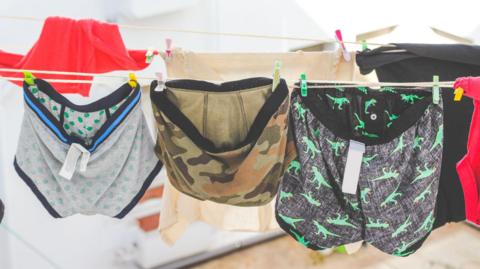 A generic picture of men's pants hanging on a washing line.