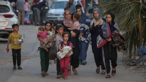 Internally displaced Palestinians, including children, walk with their belongings in central Gaza Strip. Photo: 4 June 2024