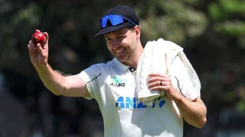 Jacob Duffy holds up a cricket ball