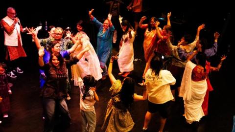 A group of people dancing on stage. 