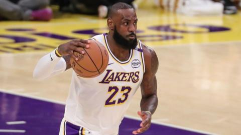 LeBron James holds the basketball in his right hand while playing for the LA Lakers